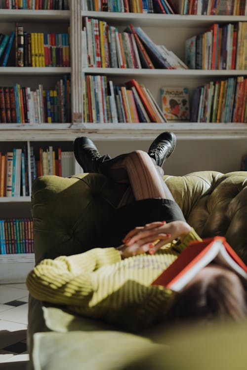 Woman in Yellow Sweater and Black Pants Sitting on Chair