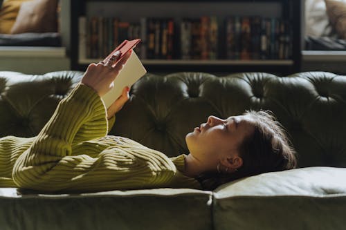 Woman in Yellow Long Sleeve Shirt Lying on Couch