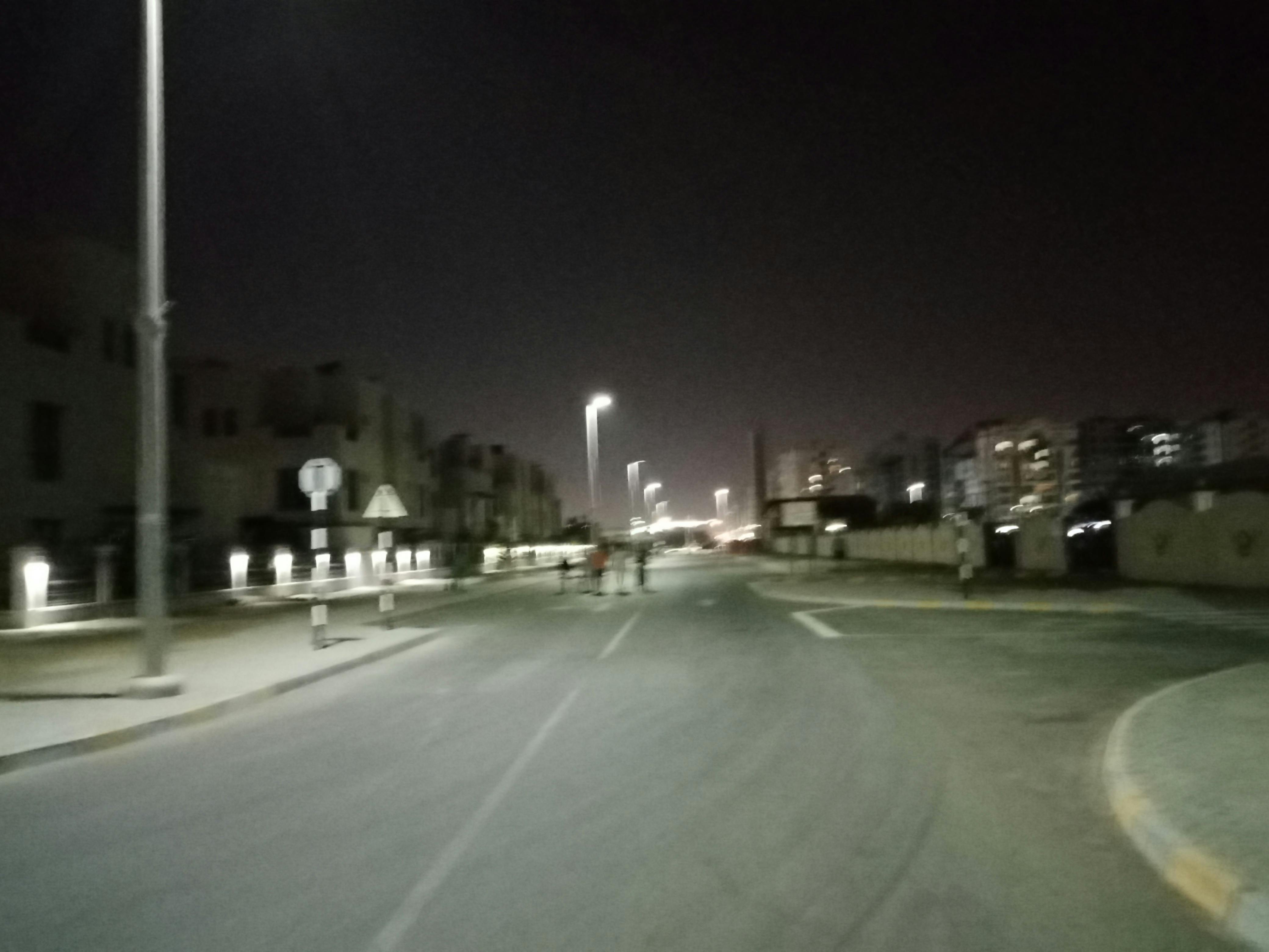 Student studying at night with a laptop and notebooks under warm light