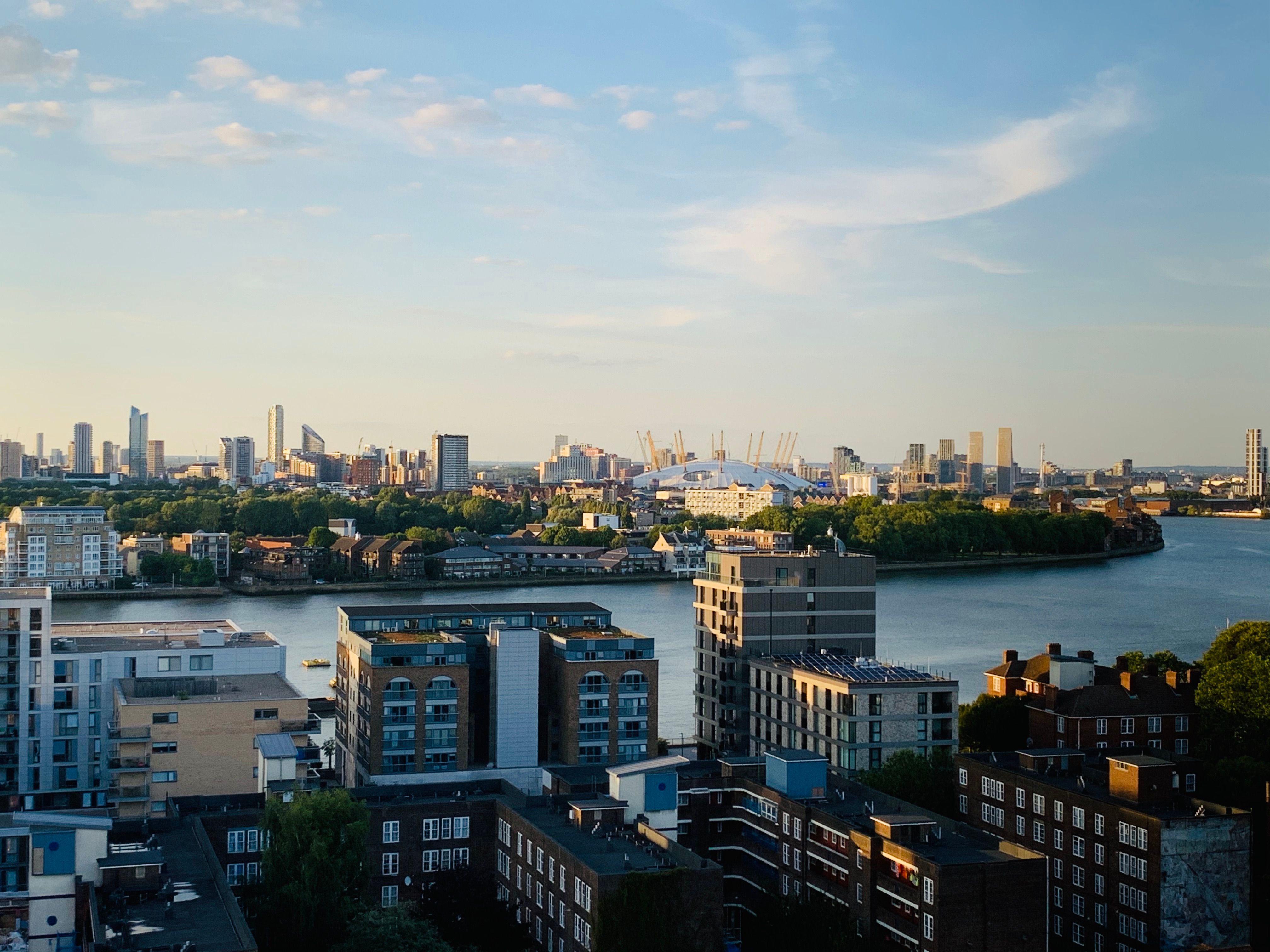 Aerial view of London's skyline with buildings and River Thames at sunset.