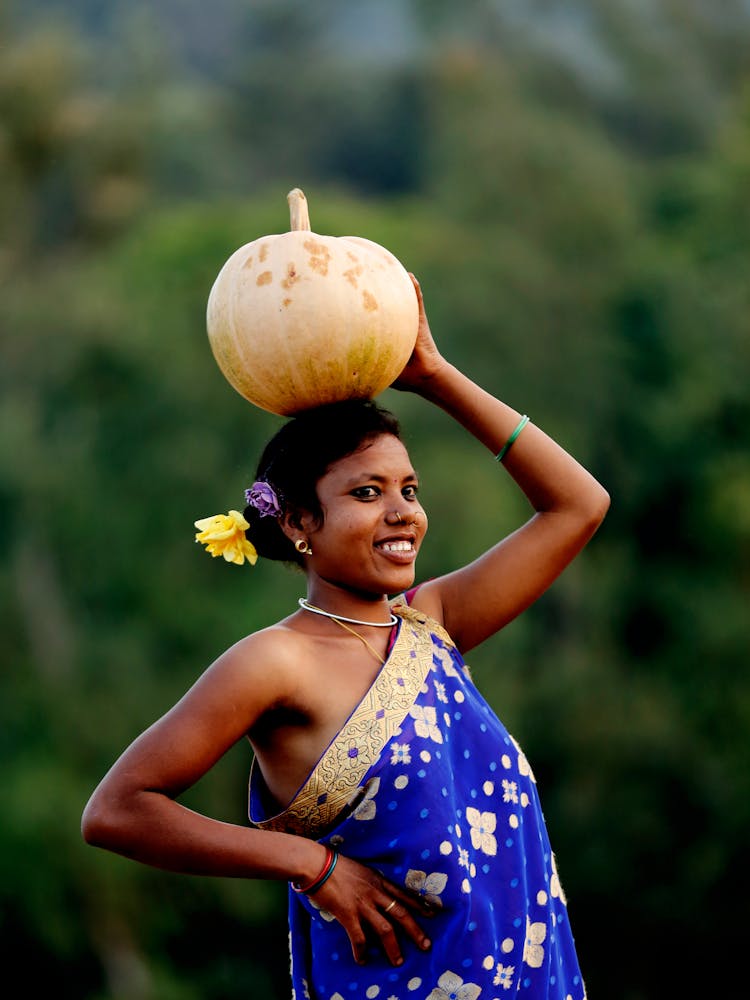 A Woman Carrying A Gourd Vegetable Ove Her Head