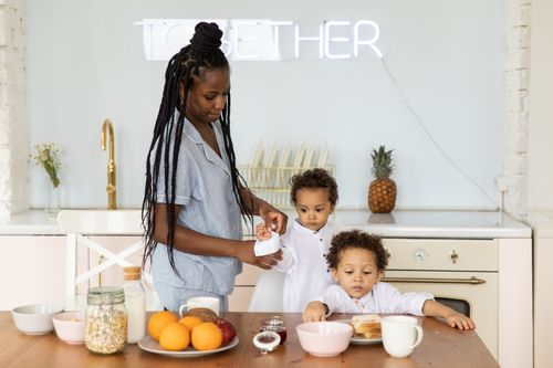 Free A mother and her children enjoy a cozy breakfast together in the kitchen. Stock Photo