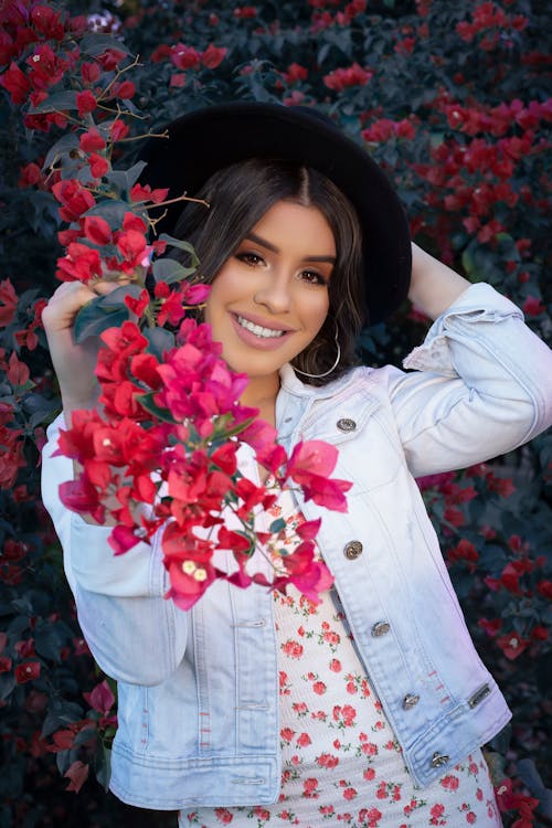 Woman in Denim Jacket Standing near Flowers