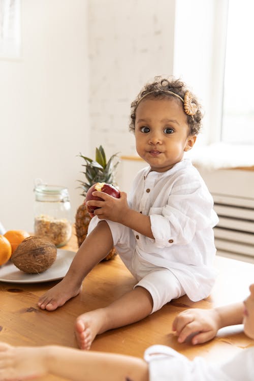 Child Sitting on Wooden Table Top 