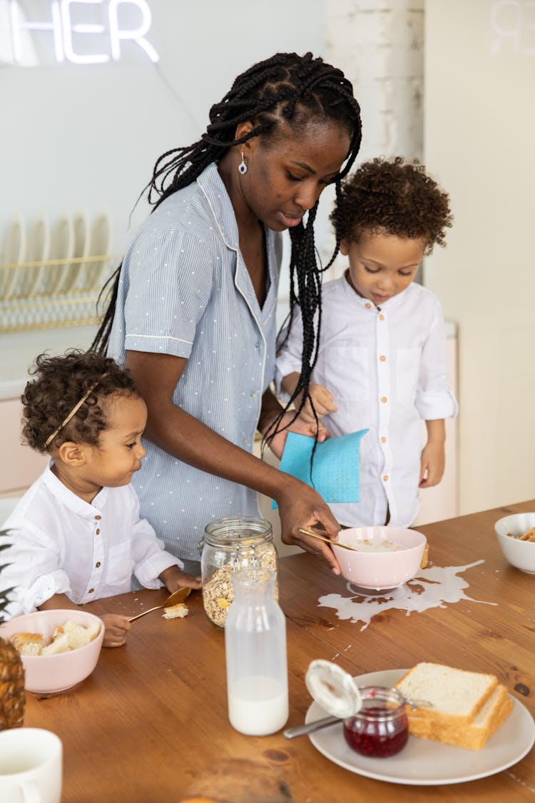 Woman Cleaning The Spilled Milk On Table 