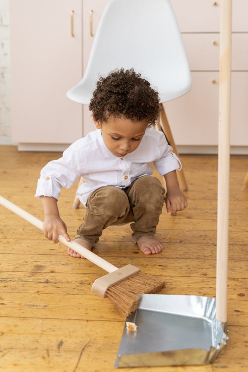 Free Child Holding a Sweeper Stock Photo