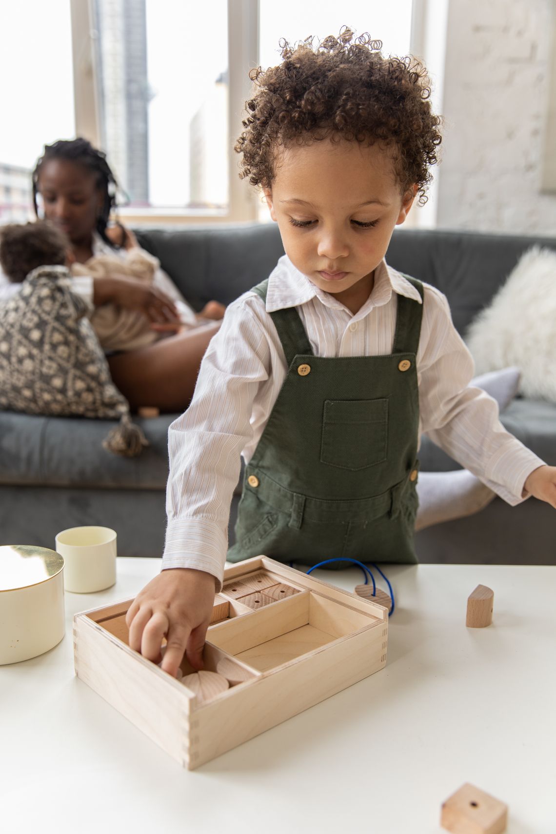 Young child concentrating on wooden building blocks during indoor learning play