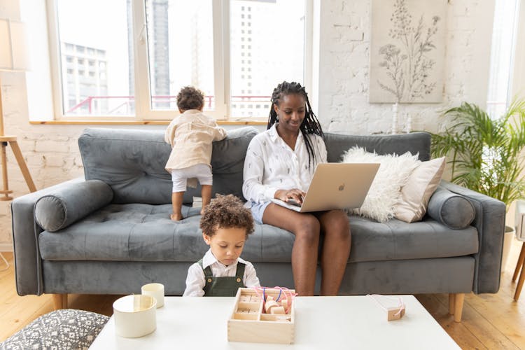 Mother Doing Remote Work With Kids Playing Around