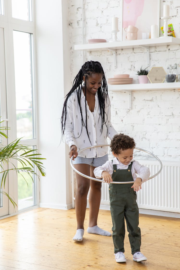 Woman Teaching Her Son Playing With A Hula Hoop