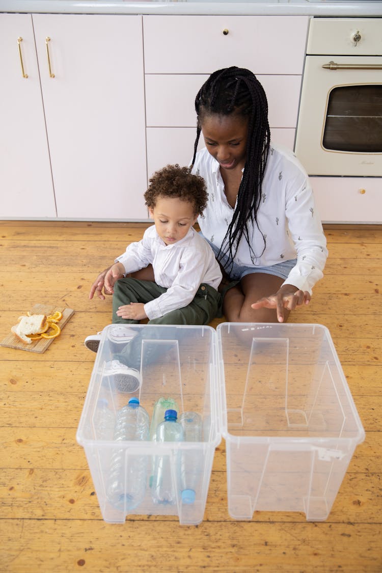 Mother And Child Throwing Trash To Boxes