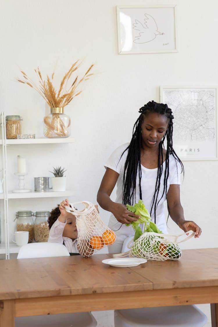 Mother And Child Taking VEgetables And Fruit From Bag