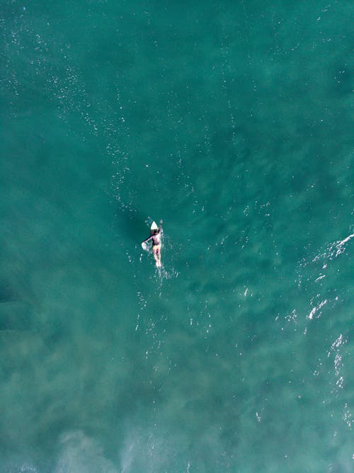 Aerial Footage of Person Surfing on Body of Water 