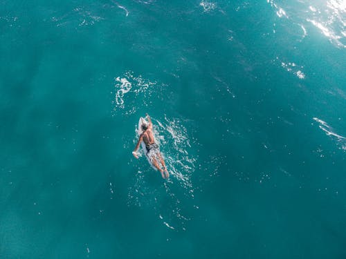 Aerial Footage of Person Surfing on Body of Water