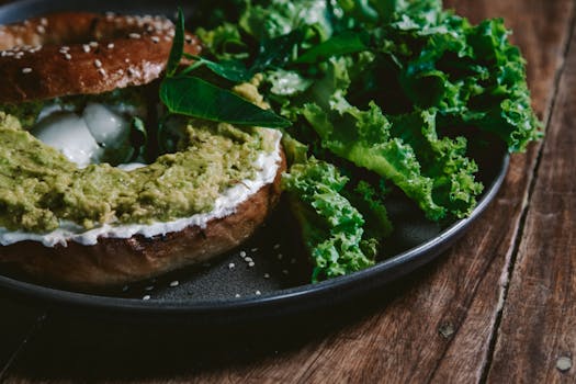 Delicious avocado bagel with cream cheese and fresh greens, perfect for a healthy breakfast.