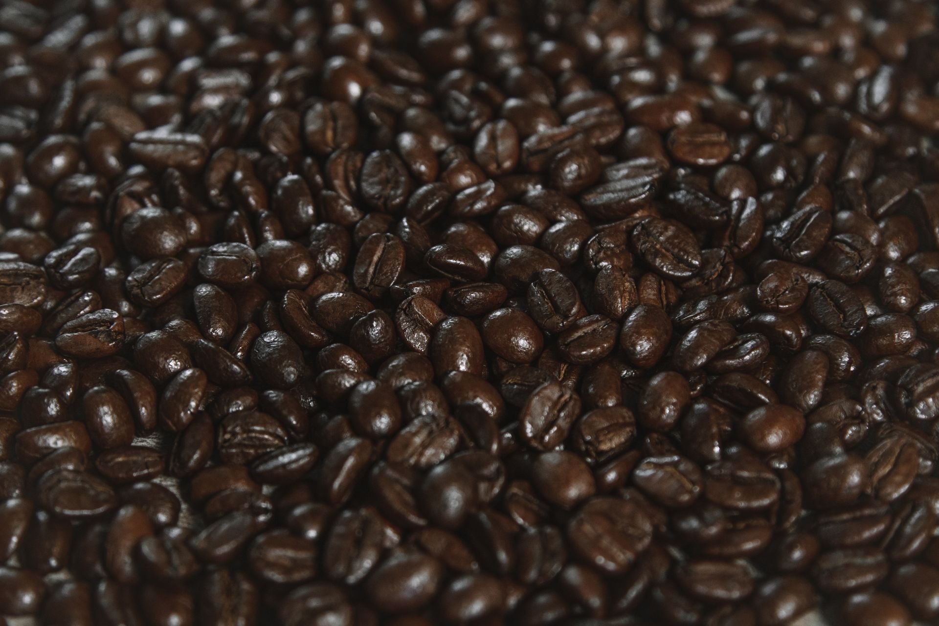 A detailed image of aromatic roasted coffee beans piled together, ideal for food and beverage themes.