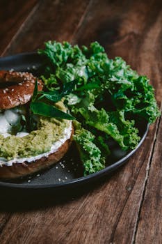 Delicious avocado bagel served with fresh green lettuce, perfect healthy snack.