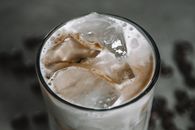 冰咖啡清爽可口，上面点缀着奶油泡沫和冰块