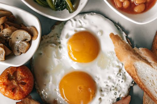Free A delectable breakfast spread featuring eggs, bread, and fresh vegetables. Stock Photo