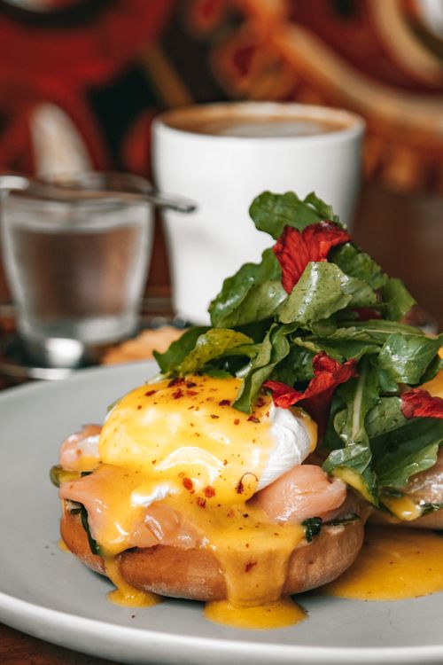 Free Savor a perfect brunch of eggs benedict with fresh greens and coffee. Stock Photo