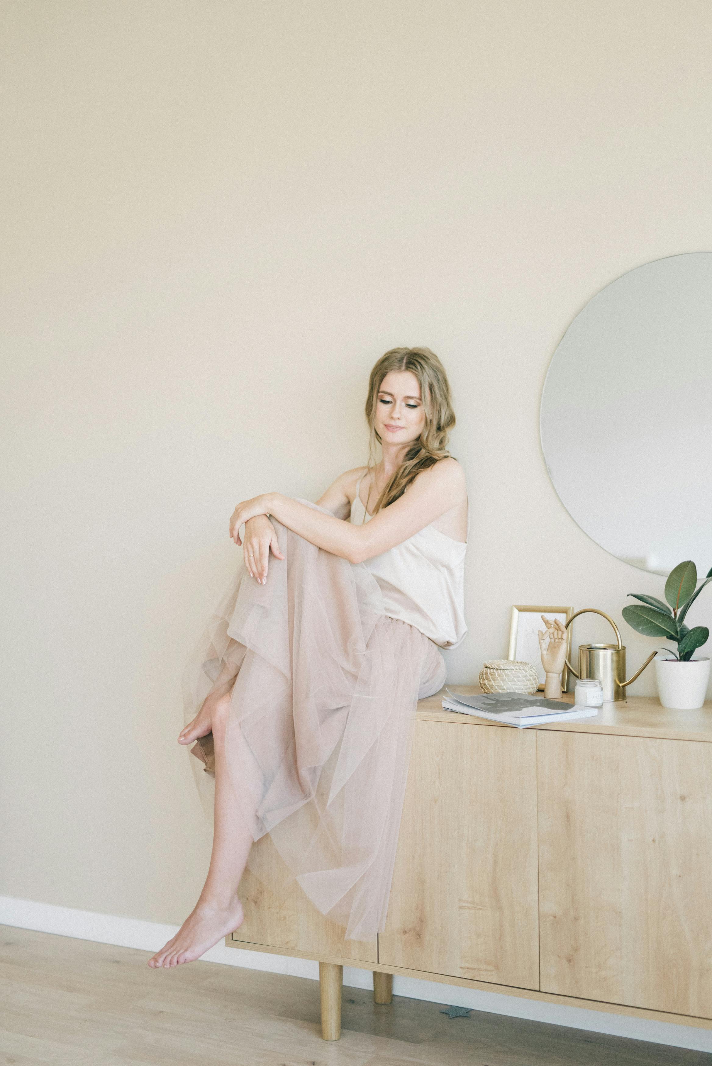 一位女士优雅地坐在中性色调极简主义房间里的宁静肖像