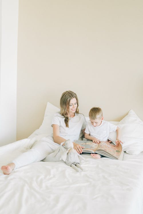 Woman And Child Sitting On The Bed