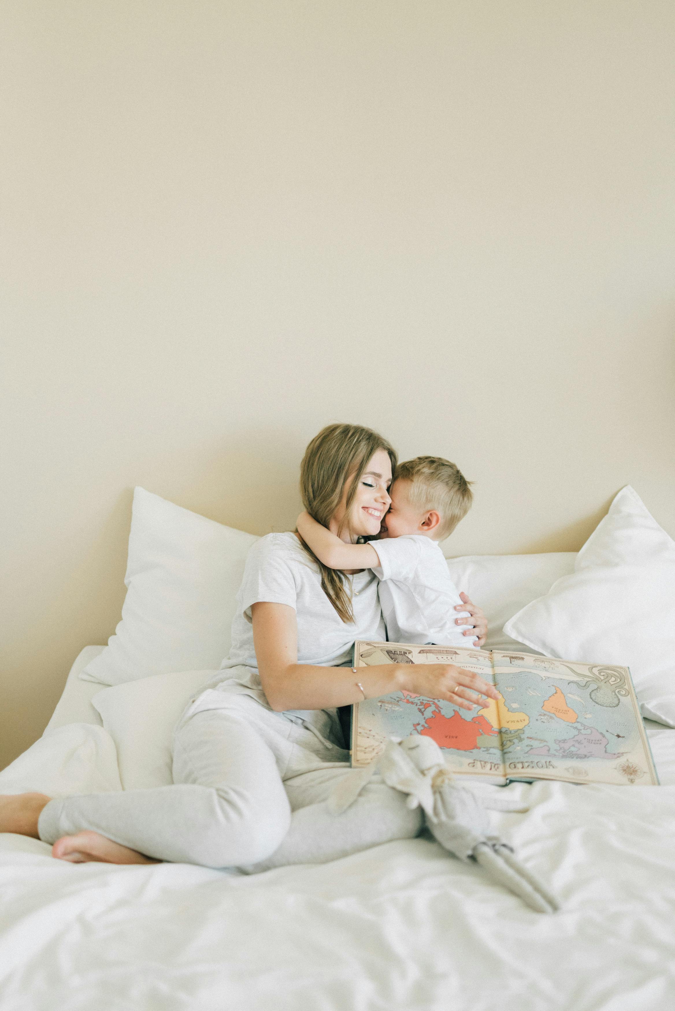 boy hugging woman in white shirt and white pants