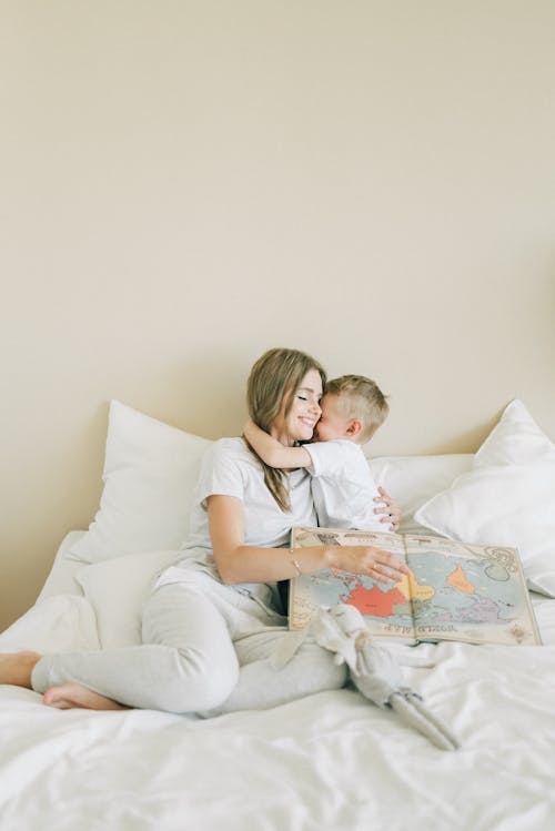 Boy Hugging Woman In White Shirt And White Pants 