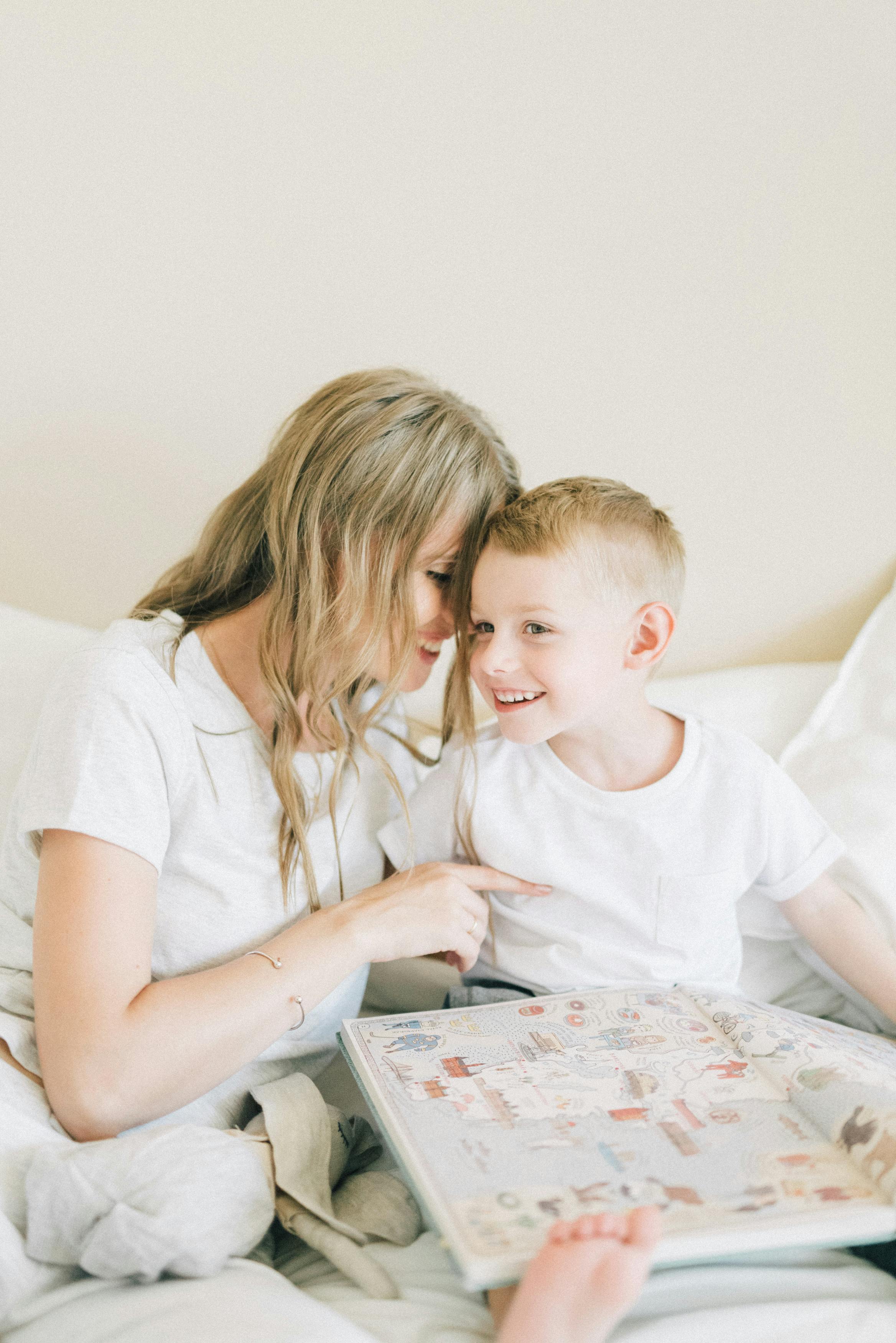 woman in white t shirt sitting beside boy in white t shirt