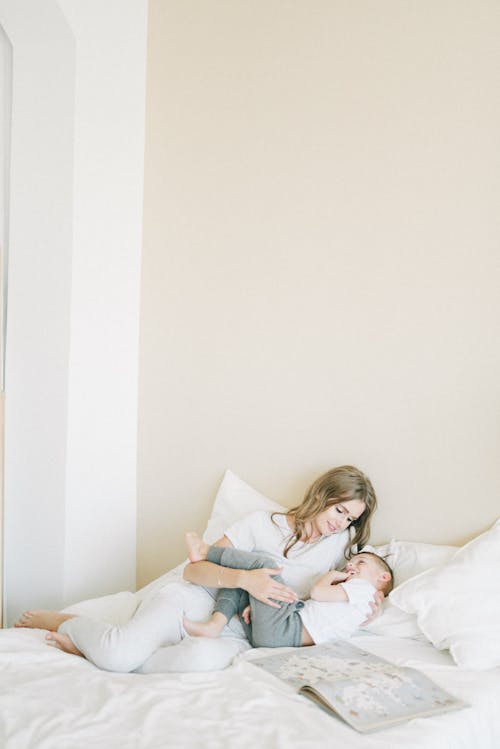 Free Woman Relaxing On The Bed With Her Child Stock Photo