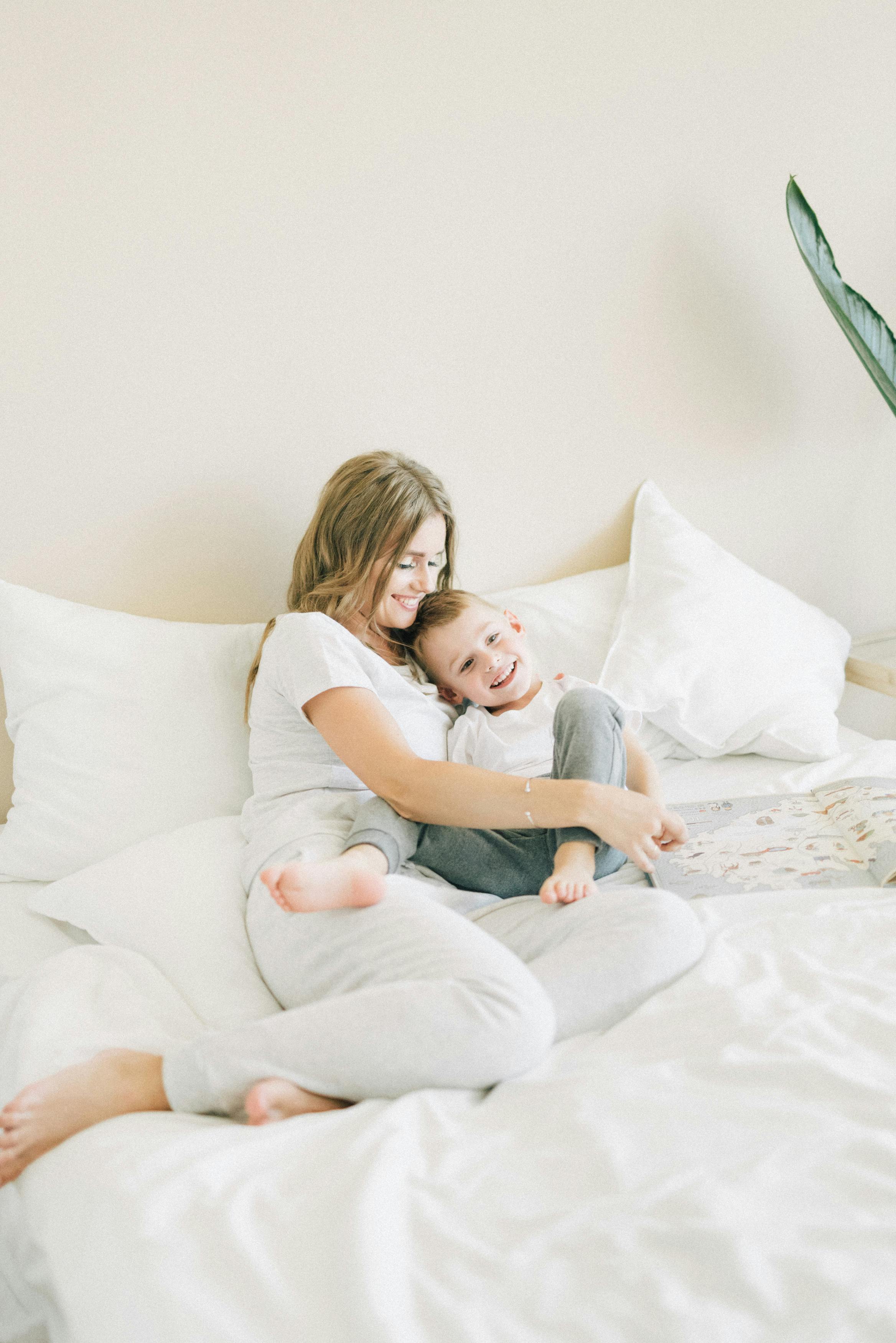 a woman holding her son on a bed