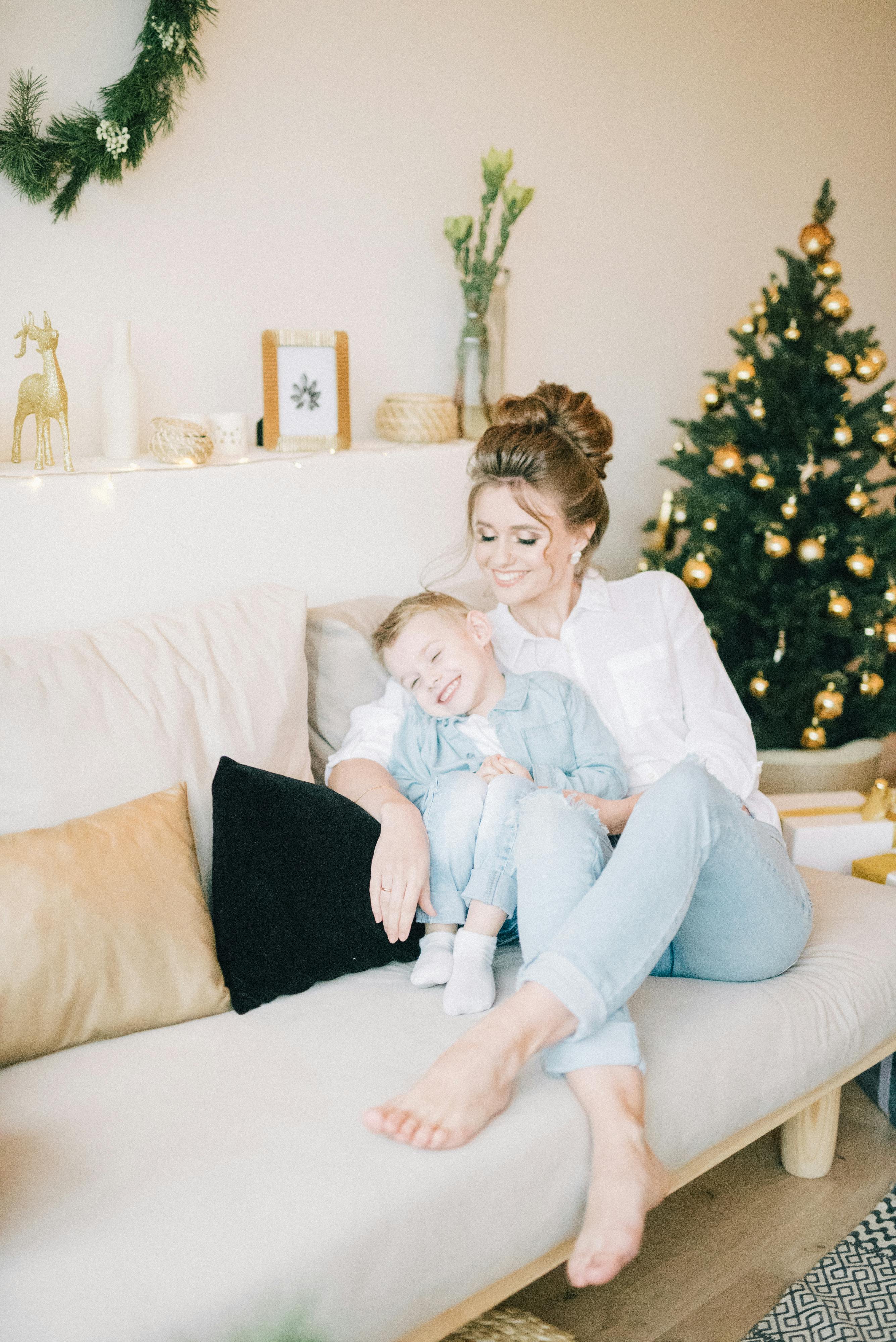 母亲和孩子在装饰着节日圣诞饰品的沙发上，享受着舒适的时刻