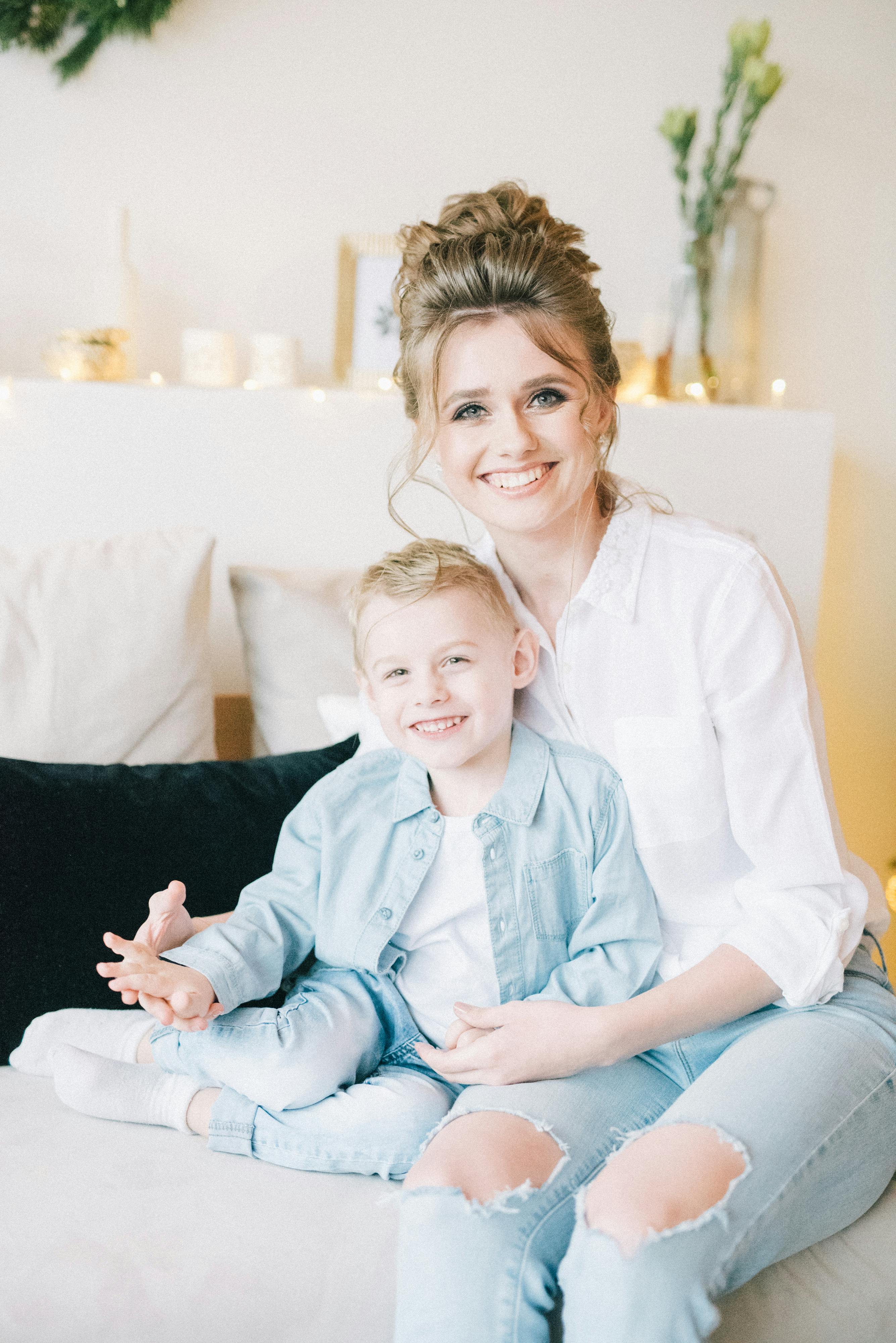 woman in white dress shirt sitting beside boy in blue dress shirt