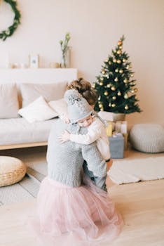 在室内圣诞树旁，母亲和孩子分享着温暖的拥抱