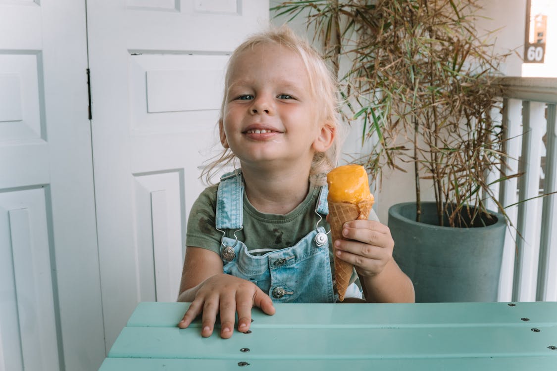 Little Girl in Denim Jumper Holding Ice Cream 