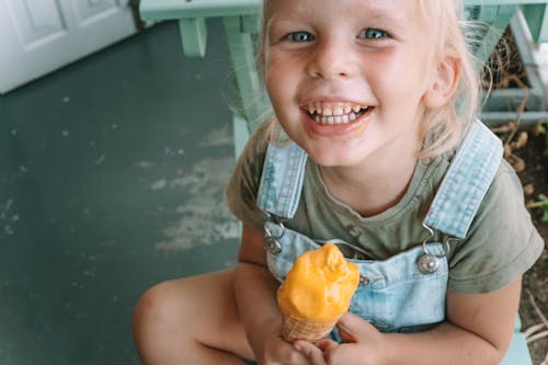 Cute Little Girl Holding Yellow Ice Cream Cone