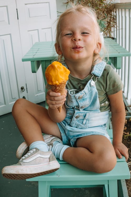 Cute Little Girl in Blue Denim Jumper Eating Ice Cream 