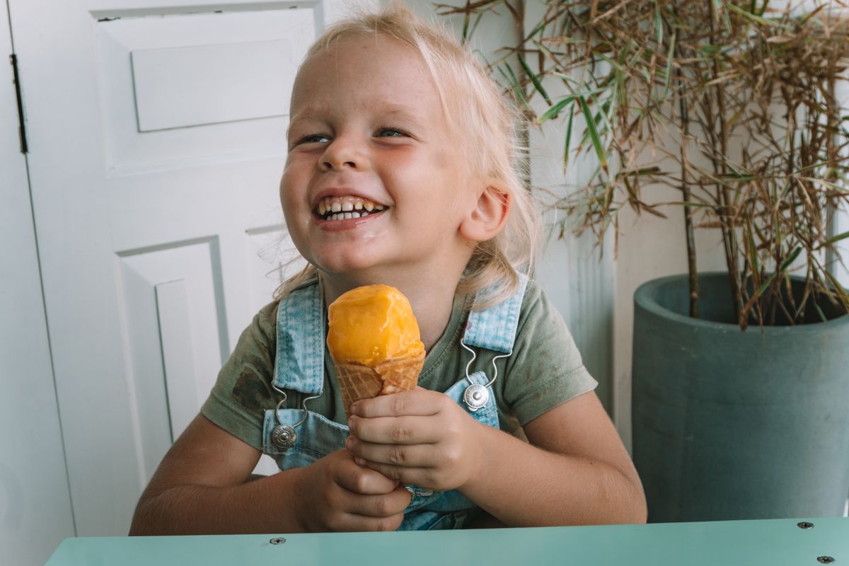 Smiling child holding an ice cream cone