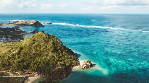Free A breathtaking aerial view of a tropical island coastline with clear blue waters and lush greenery. Stock Photo