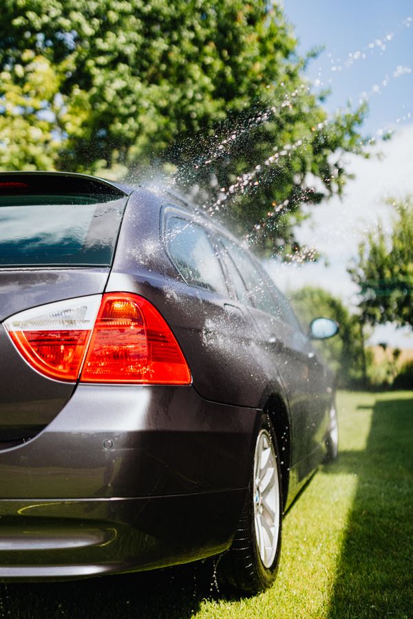 Car being rinsed outdoors
