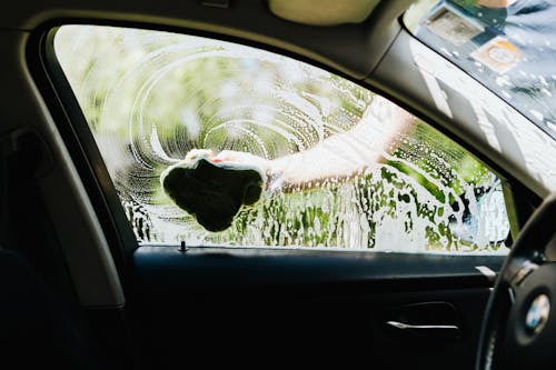 Free A Person Washing a Car Window Stock Photo