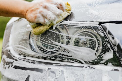 Free A Person Washing a the Headlight of a Car Stock Photo
