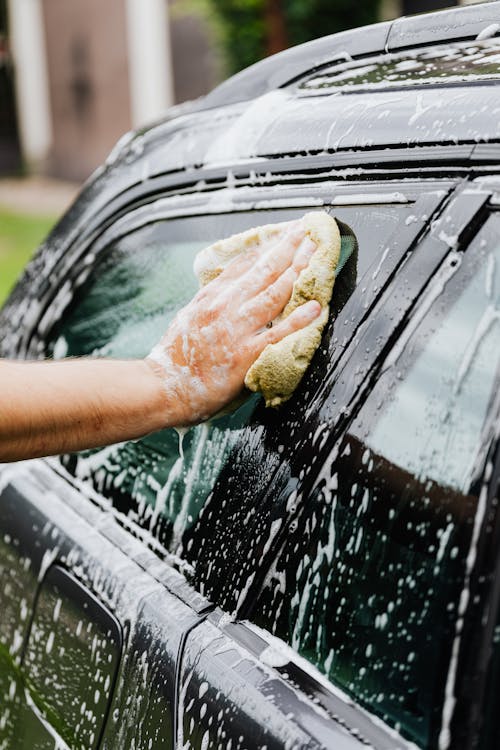 Ilustración de lavado de autos. el coche está en espuma de jabón