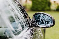 汽车后视镜上肥皂水的详细视图，突出了洗车细节