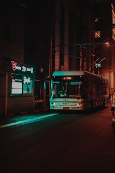 Public bus at night on a Shanghai city street, illuminated by streetlights.