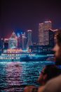 夜晚，游船穿过黄浦江，上海浦东区的天际线被灯光照亮