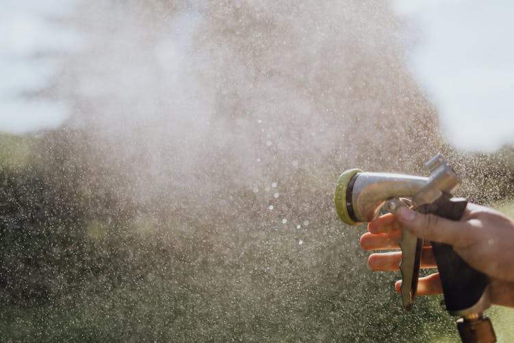 Person's Hand Using A Spray Hose