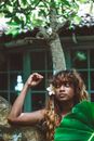 Woman with Flower in Hair Standing Under Tree