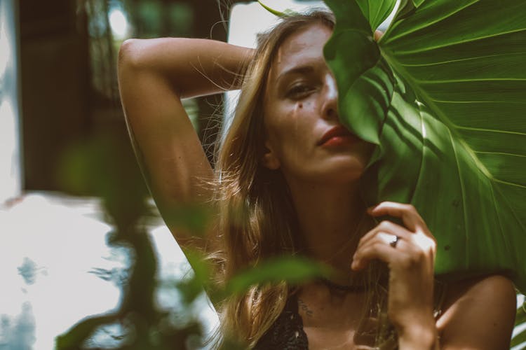 Selective Focus Photo Of A Beautiful Woman Holding A Taro Leaf