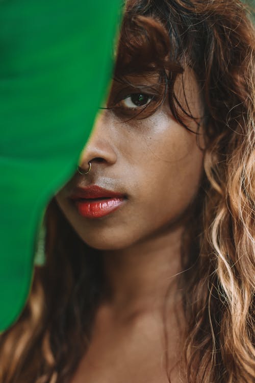 Green Leaf Covering Half of a Beautiful Woman's Face