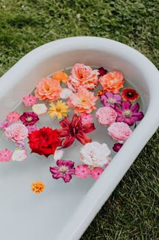 草地上，一个户外浴缸里漂浮着五颜六色的花朵，充满活力